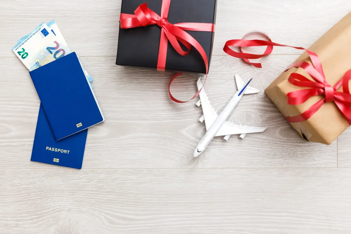 Passeports, billets d'avion, avion miniature et cadeaux emballés symbolisant un voyage en cadeau.